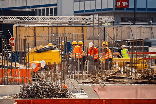 Construction workers on a site wearing yellow hard hats.
