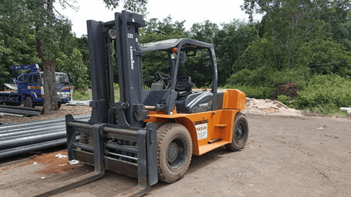 An orange forklift truck on a construction site.