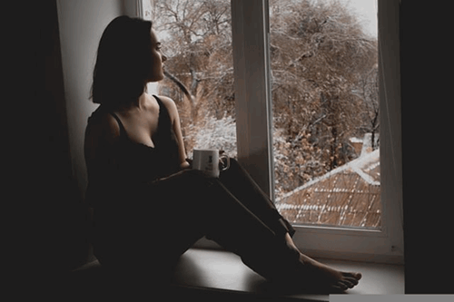 A woman sitting down looking out of the window.