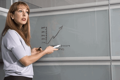 A woman looking at results on a whiteboard.