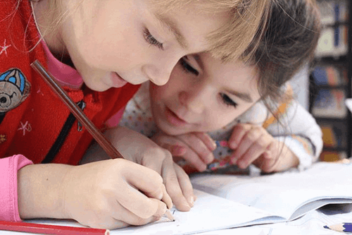 Two children writing.