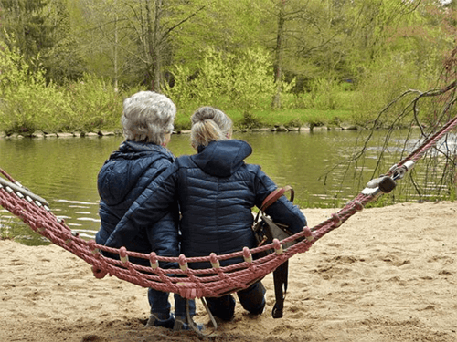 Elderly women sitting on a hammock.