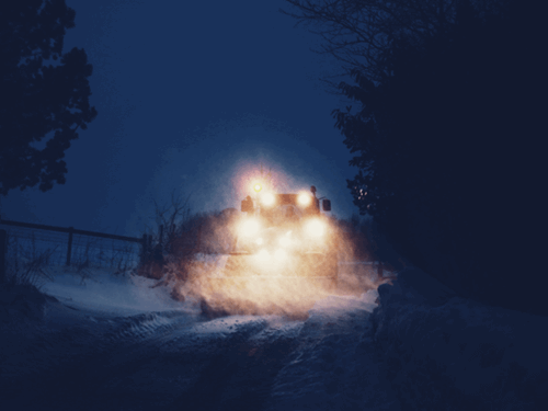 truck ploughing snow at night