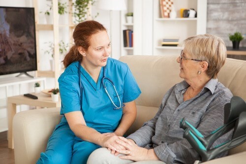 A healthcare worker talking to an elderly patient.