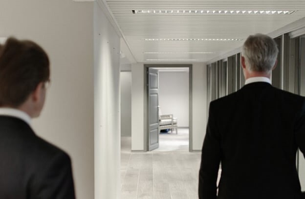 Two people walking into a room, possibly for a job interview