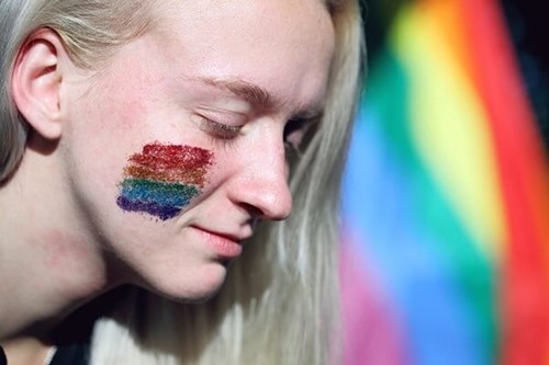 someone wearing rainbow face glitter