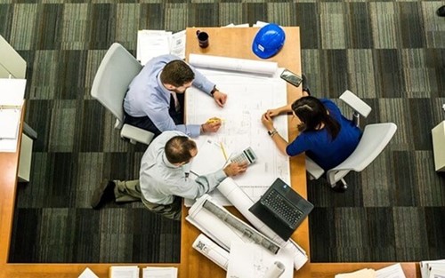 a group of employees looking at plans
