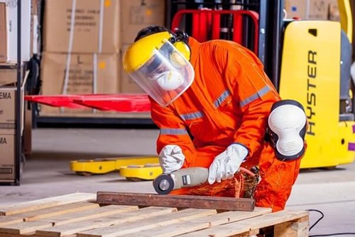 An employee wearing PPE and a protective jumpsuit